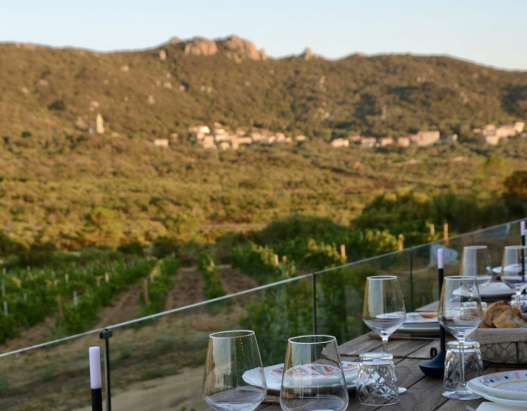 Table dressée au sein de la cave, en vue d'une dégustation ou d'un dîner en cave, en fin de journée avec la colline en arrière plan